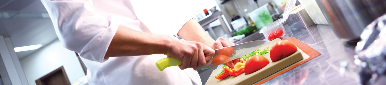 Chef cutting vegetables in professional kitchen